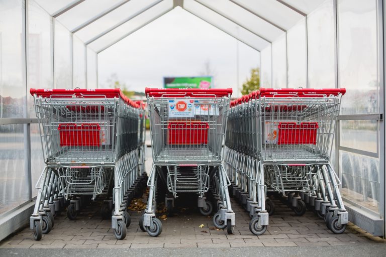 A row of branded trolleys lined up at a trolley bay